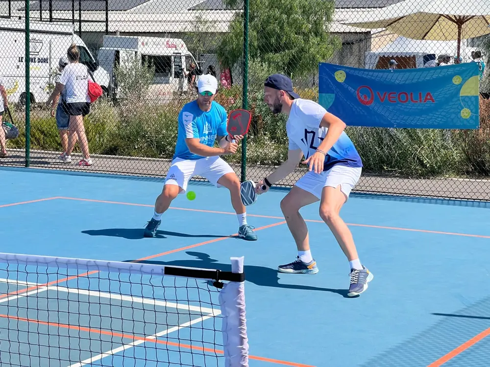 Dos jugadores disputando un punto en la pista de pickleball