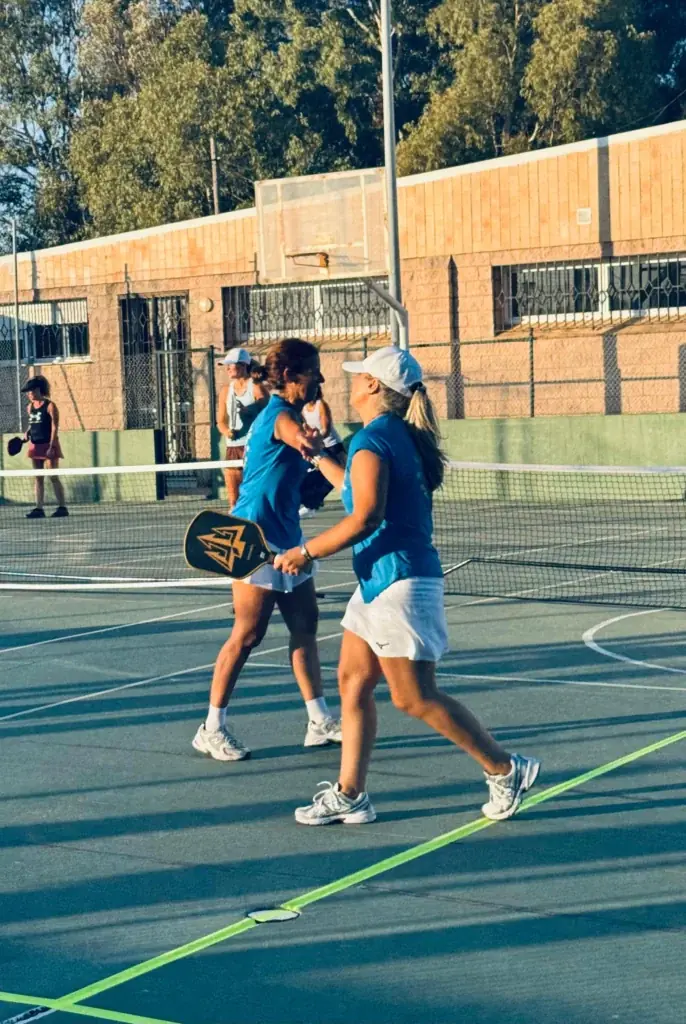Pareja de jugadoras chocando la mano durante un partido